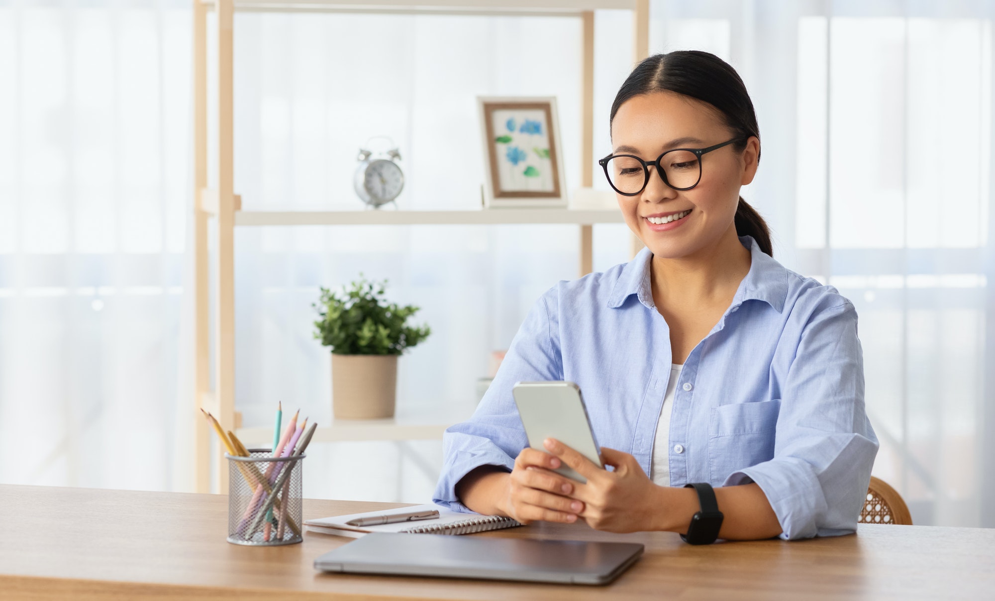 Pretty young asian lady entrepreneur using business mobile app